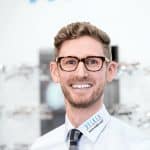 MitarbeiterPortrait für den Optiker delker aus Mannheim. netter Mann mit Brille.