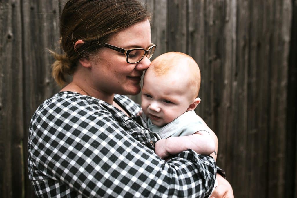 Fotostudio Thomas hat Bilder vor Holzwand in Mutterstadt gemacht. Von Frau mit Baby.